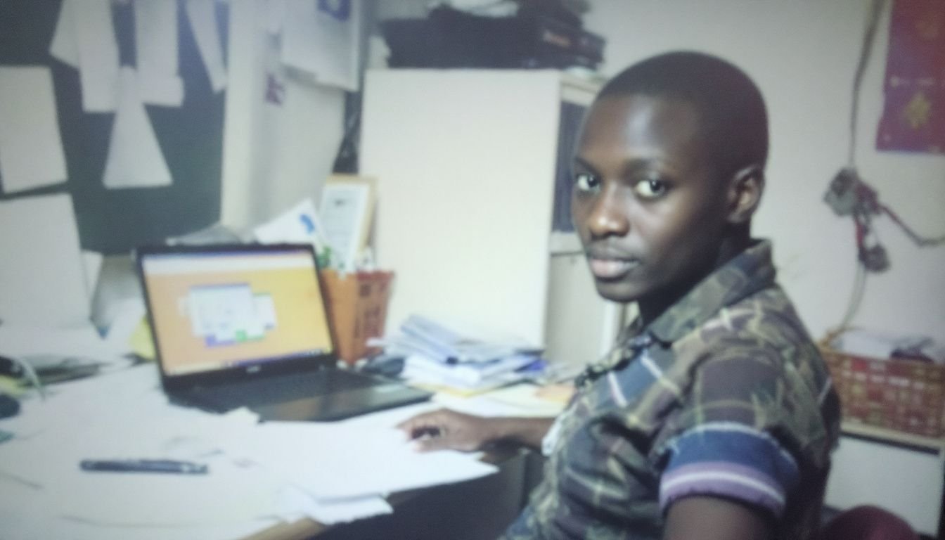 A person sitting at a cluttered desk with a laptop and papers.